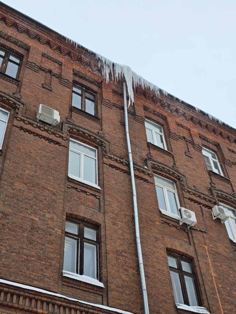 Сосульки на кровле кирпичного здания в Москве до очистки